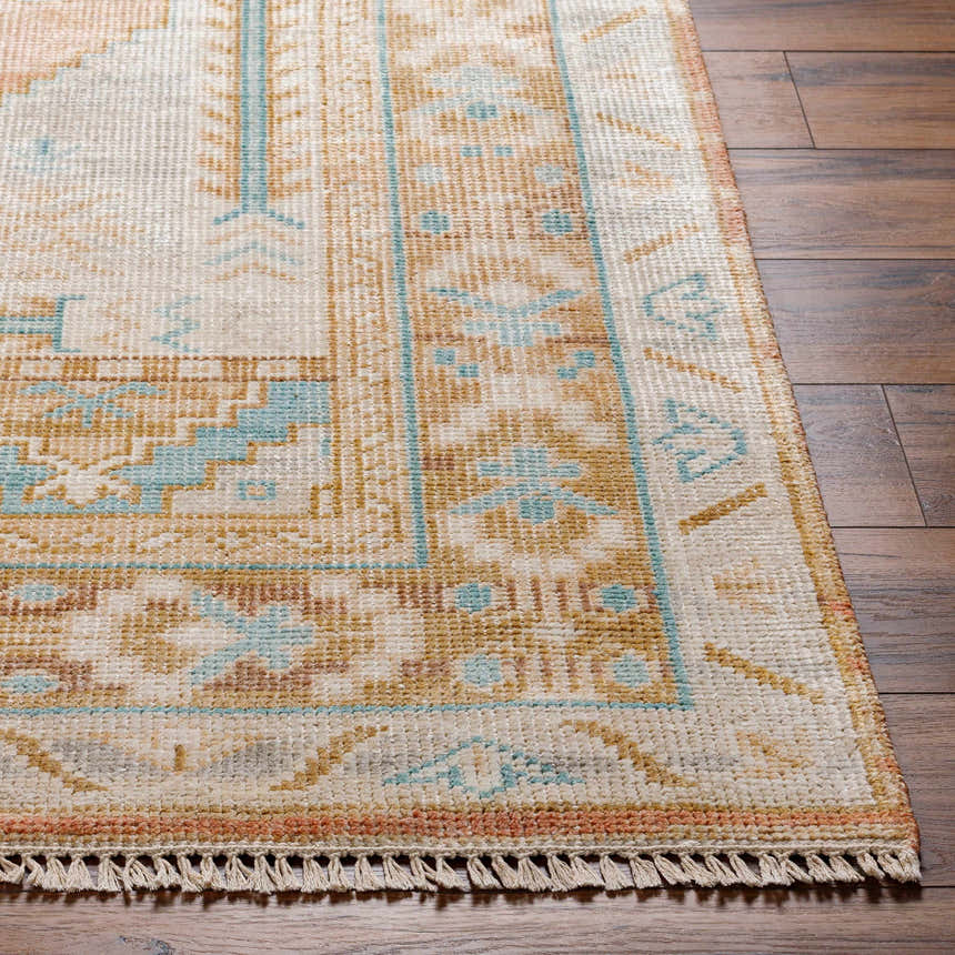 Close up of the hand-knotted Aliang Premium Rug showing its camel, blue, and cream traditional pattern and wool texture. Front
