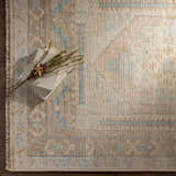 Close-up of the hand-knotted Aliang Premium Rug. Features a traditional design in camel, cream, and light blue wool. Styleshot