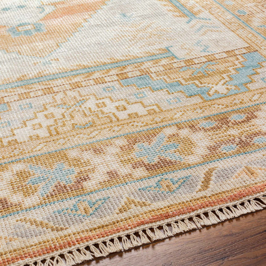 Close-up of the hand-knotted Aliang Premium Rug. Features traditional patterns in blue, camel, cream, and pink tones. Texture