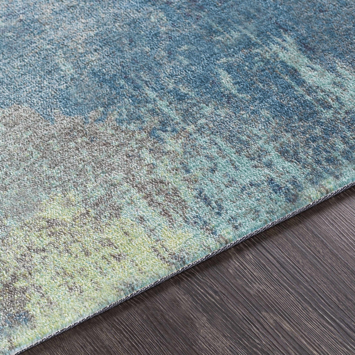 Close-up of the Alvaton Abstract Blue Rug showing its blue, gray, and light beige abstract pattern and soft texture. Texture