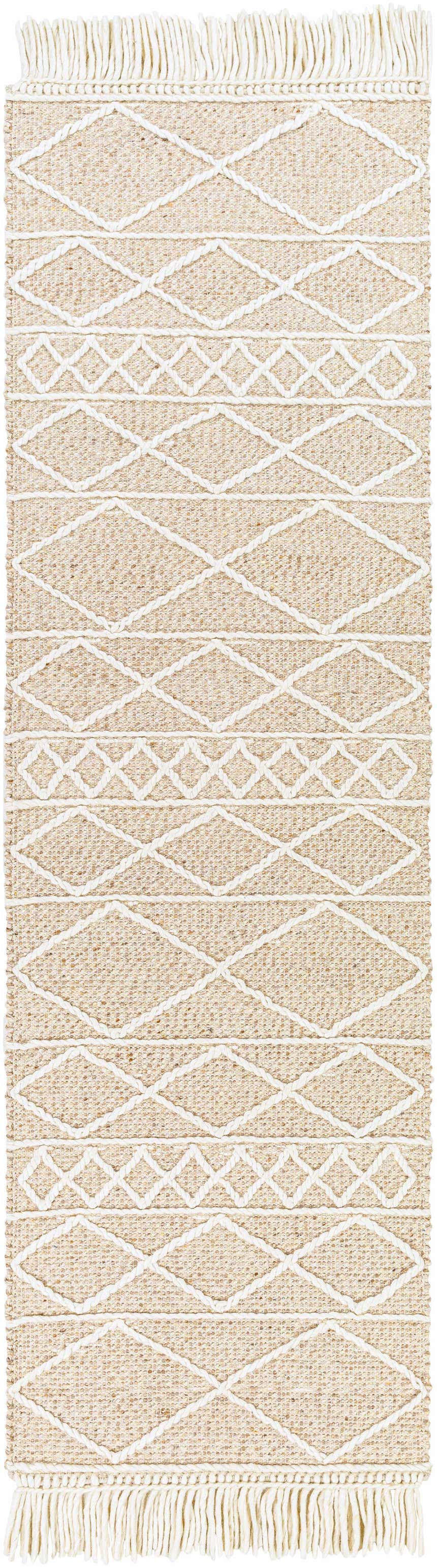 Close-up of the Ambulong Area Rug. Cream and tan rug with white geometric diamond pattern and fringe. Hand woven wool and cotton. Design-Runner-268