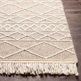 Close-up of a cream Ambulong Area Rug. Hand-woven wool and cotton rug with geometric pattern and fringe detail. Front
