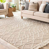 Living room scene with a cream sofa and the Ambulong Area Rug in cream and tan with a geometric design. Roomscene-Rectangle