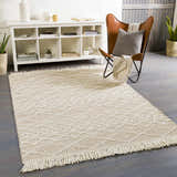 Living room scene with a cream Ambulong Area Rug, brown leather chair, and white shelving unit. Roomscene-Rectangle