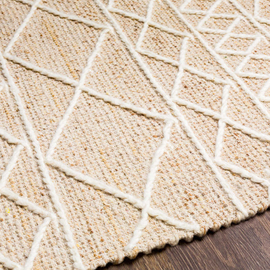 Close up of the Ambulong Area Rug's cream and tan wool texture with a raised geometric pattern. Hand woven rug detail. Texture