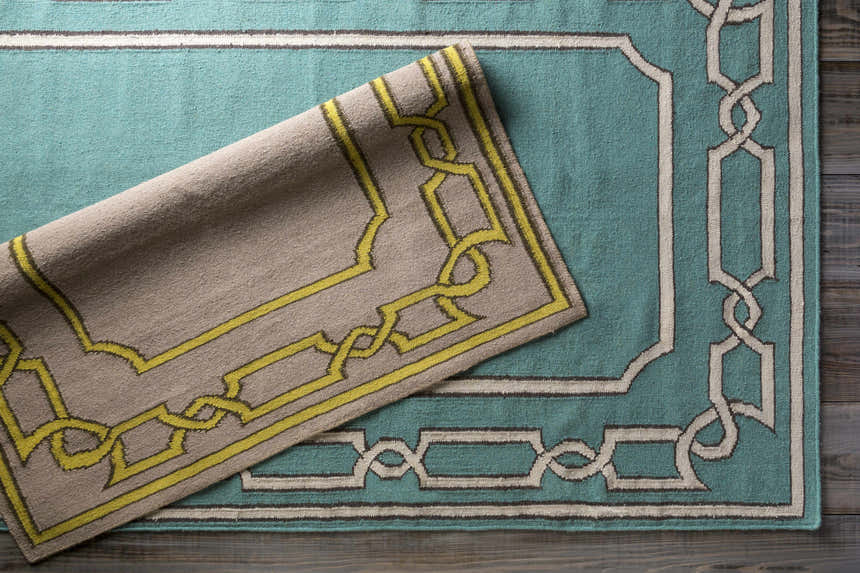 Close-up of the hand woven Fruitvale Area Rug. Features a geometric pattern in dark brown, tan, and taupe. Styleshot