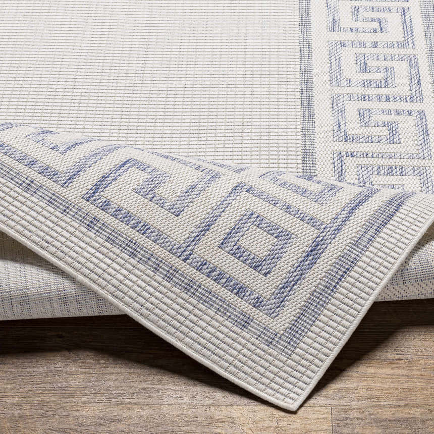 Close-up of Alen Cream & Blue Indoor Outdoor Rug showing geometric Greek key pattern and textured weave. Fold