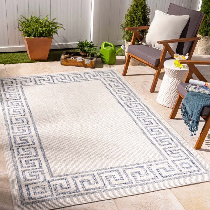 Outdoor patio scene with Alen Cream & Blue Indoor & Outdoor Rug, gray chairs, white side table, and potted plants. Roomscene-Rectangle