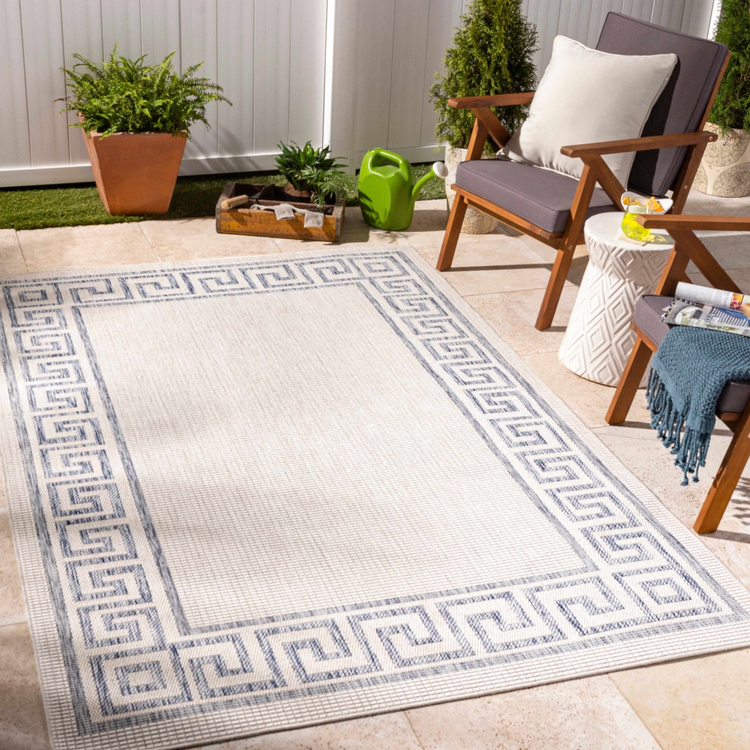 Outdoor patio scene with Alen Cream & Blue Indoor & Outdoor Rug, gray chairs, white side table, and potted plants. Roomscene-Rectangle