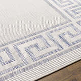 Close-up of the Alen Cream & Blue Indoor/Outdoor Rug showing a traditional Greek key border pattern and textured weave. Texture