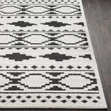 Close-up of Amoret Area Rug showing black geometric pattern on off-white, textured pile. Front
