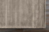 Close-up of the charcoal Angie Area Rug showing its hand-loomed, striped texture on dark wood flooring. Corner