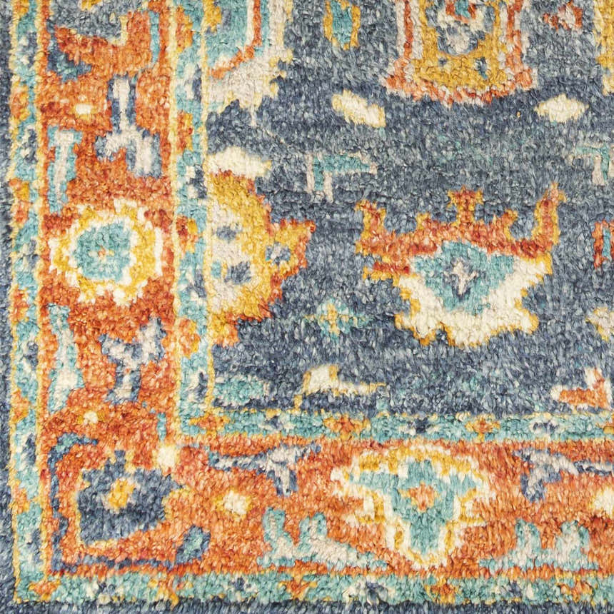 Close up of the Ankara Premium Wool Area Rug, featuring a traditional pattern in navy, orange, aqua, and mustard. Swatch