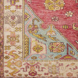 Close-up of the Anopog Washable Area Rug, a machine-woven rug with a farmhouse design in red, blue, yellow, and cream. Swatch