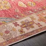 Close-up of the Anopog Washable Area Rug. Farmhouse style rug in red, gold, and beige with a traditional, intricate pattern. Texture