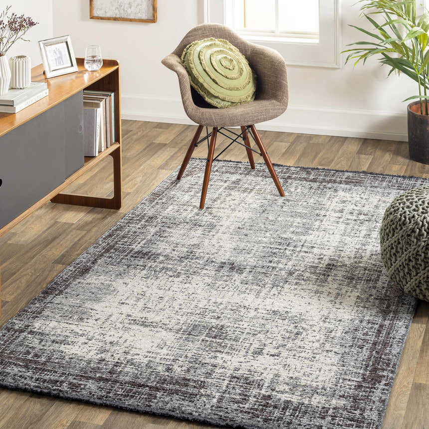 Living room scene with charcoal and cream Binh Gray Area Rug, chair, pouf, and mid-century modern console. Roomscene-Rectangle