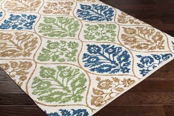 Close-up of Arecibo Clearance Rug. Hand-woven cotton rug with aqua, beige, blue, brown, and green floral pattern. Corner