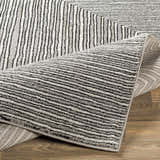 Close-up of the Artois Area Rug showing its black, cream, and gray striped pattern and textured jute and polypropylene material. Fold