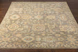 Close-up of the hand-knotted Asotin Area Rug. Features traditional burnt orange, charcoal, mustard, olive, and seafoam colors. Front