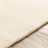 Close-up of the beige Atlas Carpet showing its hand-knotted construction and subtle ribbed texture. Texture