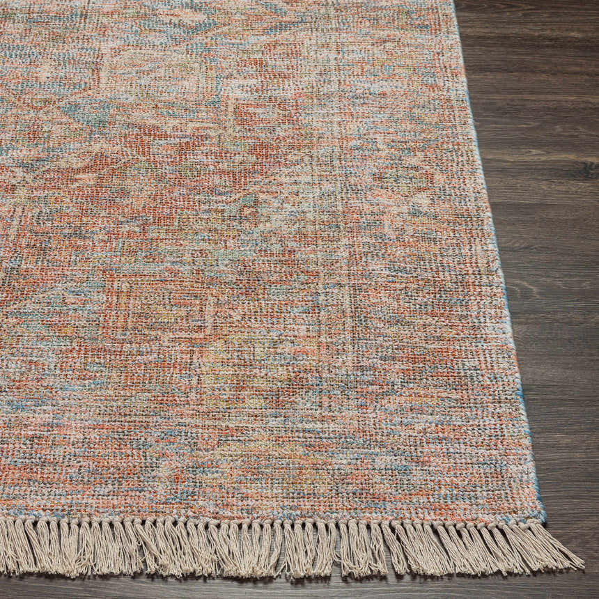 Close-up of the hand woven Atulayan Premium Rug. Bohemian style rug in blue, coral, and gray with fringe. Front