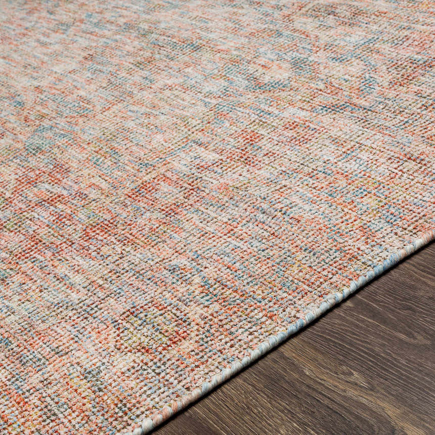 Close-up of the hand woven Atulayan Premium Rug, showcasing its blue, coral, and beige bohemian pattern and textured weave. Texture