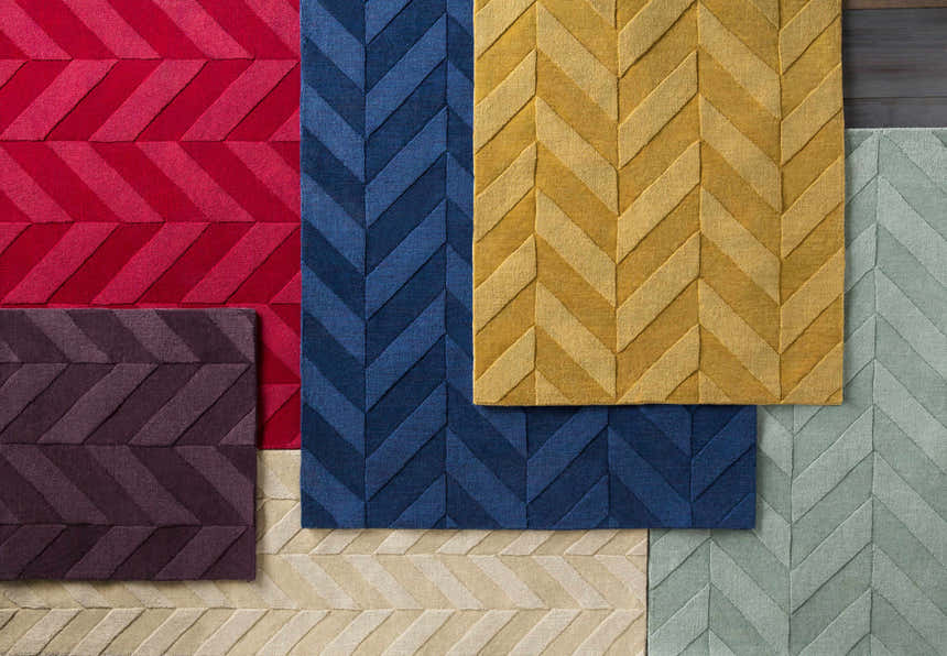 Close-up of Searsmont Area Rug in red, navy, gold, plum, beige, and light blue, featuring a textured chevron pattern. Styleshot