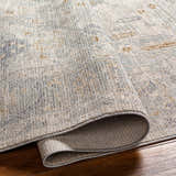 Close up of Ayarn Thick Luxe Statement Rug showing brown, gray, and teal tones and soft, textured pile. Fold