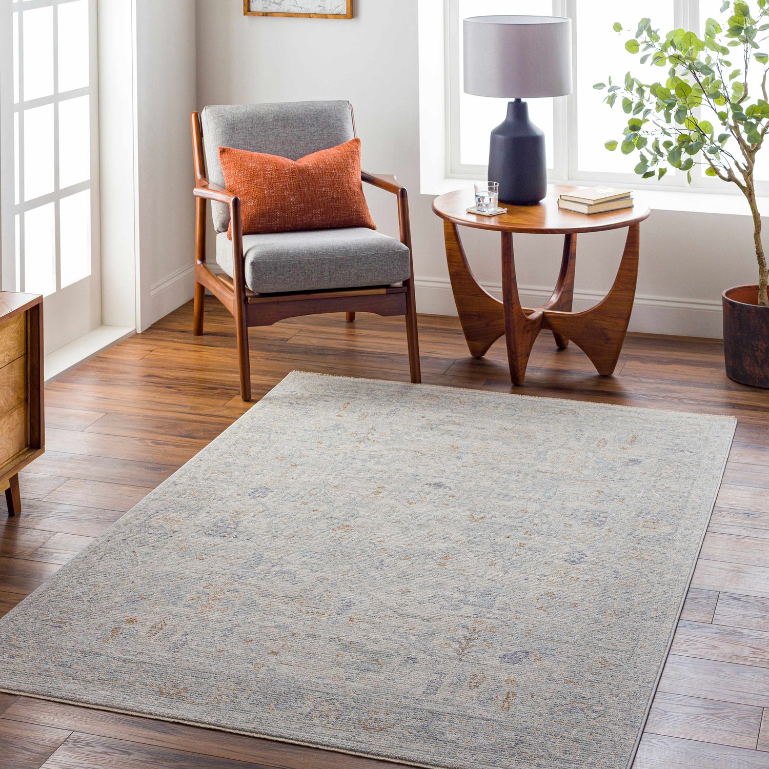 Living room scene with a gray chair, wood side table, and the Ayarn Thick Luxe Statement Rug in gray and brown tones. Roomscene-Rectangle