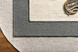 Close up of the Innisfail Area Rug. Black and medium gray striped, hand woven cotton and recycled PET yarn texture. Styleshot