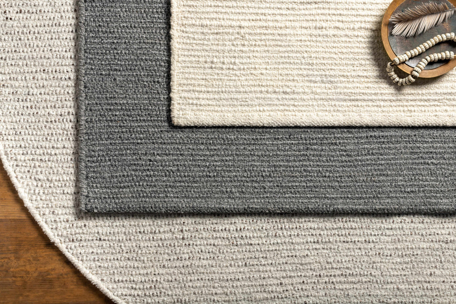 Close up of the Innisfail Area Rug. Black and medium gray striped, hand woven cotton and recycled PET yarn texture. Styleshot