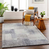 Living room scene with gray chair, wood side table, and gray Bacca Area Rug. Roomscene-Rectangle