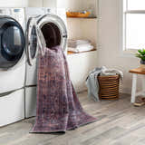 Laundry room scene with Dusty Pink Bagacay Distressed Washable Area Rug coming out of the washing machine. Washing-Machine