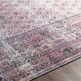 Close-up of the Dusty Pink Bagacay Distressed Washable Area Rug showing its oriental pattern, cream, pink, and blue colors. Texture