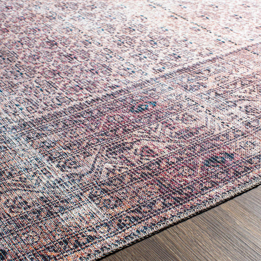 Close-up of the Dusty Pink Bagacay Distressed Washable Area Rug showing its oriental pattern, cream, pink, and blue colors. Texture
