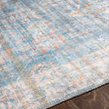 Close-up of the Bagontapay Washable Area Rug showing its blue, cream, and light brown traditional pattern and chenille texture. Texture