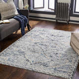 Living room scene with a Balamban Area Rug in brick red, cream, denim, and gray colors on a dark wood floor. Roomscene-Rectangle