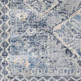 Close-up of the Balamban Area Rug, showcasing its denim, gray, and cream bohemian pattern and soft polyester texture. Swatch