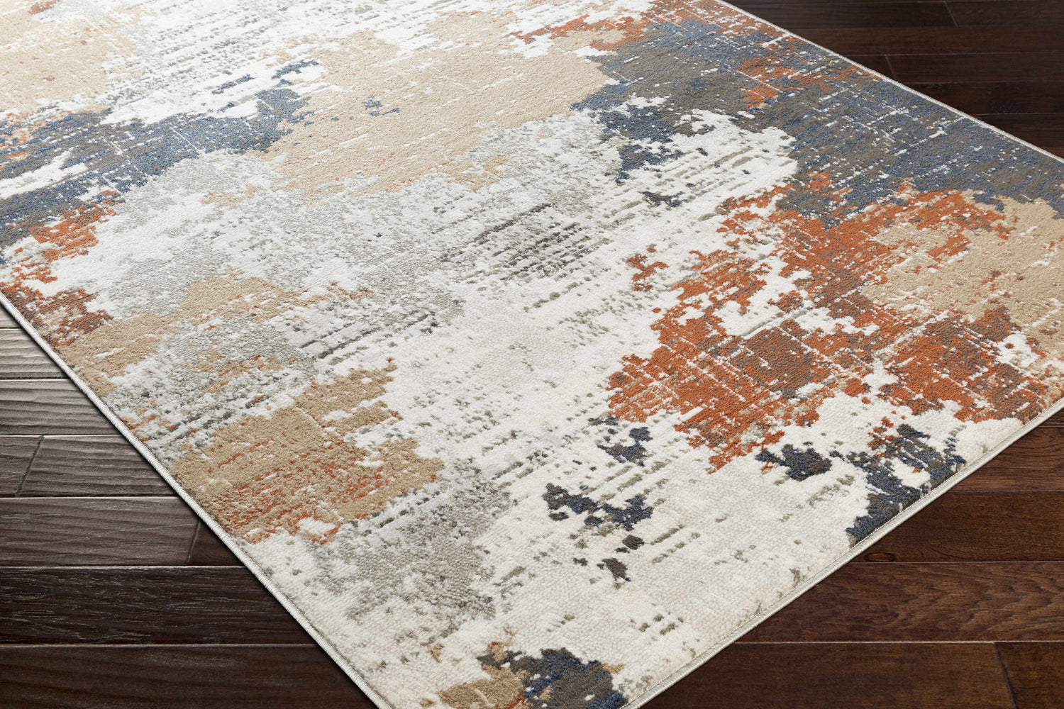 Close-up of the Balerno Area Rug showing the charcoal, blue, gray, mustard, terracotta, and white contemporary design. Corner