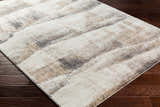 Close-up of the Banji Abstract Waves Area Rug. Beige, gray, and brown tones create a contemporary pattern. Corner