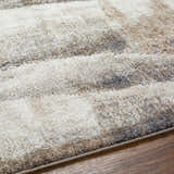 Close up of the Banji Abstract Waves Area Rug showing beige, gray, and brown tones. Texture