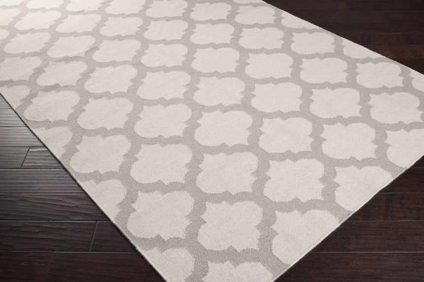 Close-up of the Banks Ivory/Gray Trellis Wool Rug showing the trellis pattern and wool texture on dark wood floors. Corner