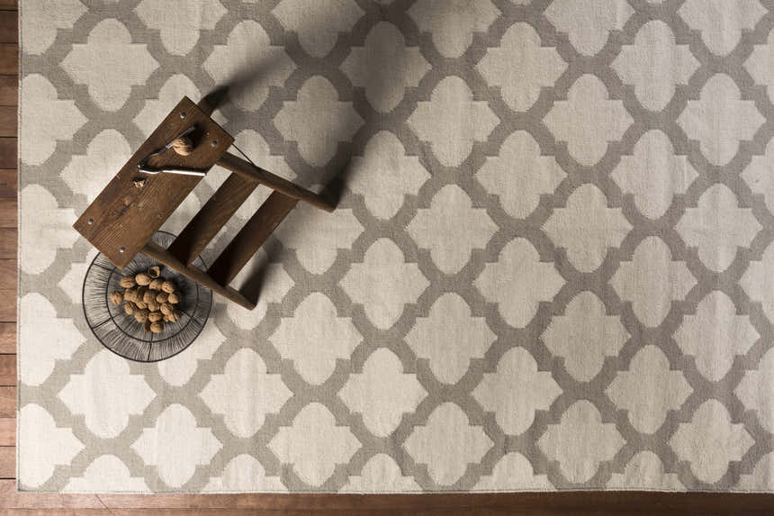 Close-up of the Banks Ivory/Gray Trellis Wool Rug. Features a gray quatrefoil pattern on an ivory background. Styleshot