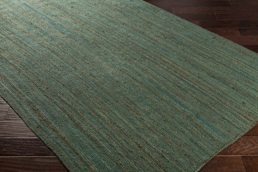 Close-up of the Barksdale Green Hand Woven Jute rug showing its charcoal, mint colors, and natural fiber texture. Corner