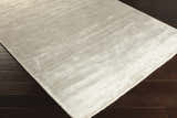 Close-up of the white Barree Area Carpet showing its contemporary design and soft, viscose texture on dark wood flooring. Corner