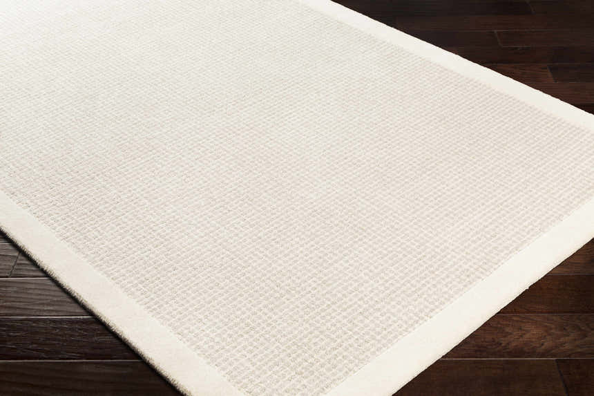 Close-up of the hand-tufted Barrow Wool Rug. Cream and light gray solid striped rug with subtle texture. Corner