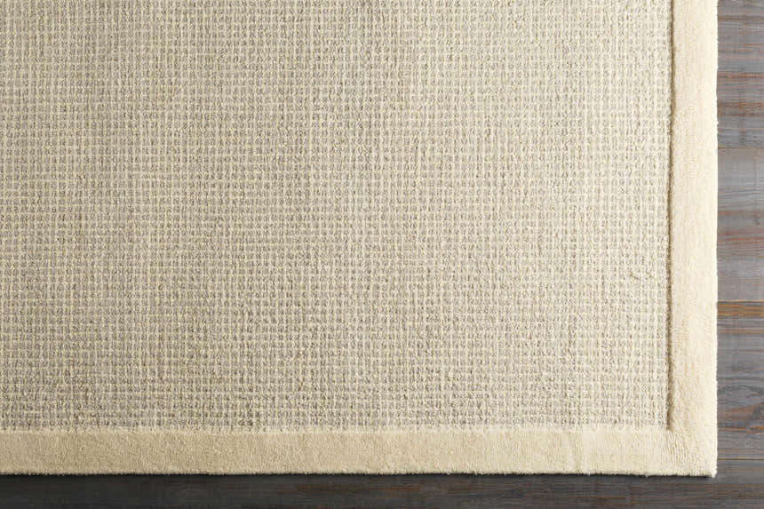 Close-up of the hand-tufted Barrow Wool Rug. Cream and light gray rug with a solid and striped contemporary design. Corner