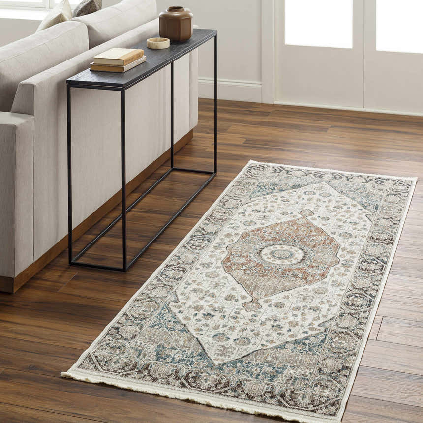 Living room scene with a cream sofa, console table, and the Baychester Area Rug in cream, brown, and blue tones. Roomscene-Runner