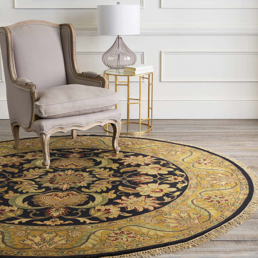 Traditional living room with a round, floral Bays Area Carpet in amber, brown, and blue tones. Wingback chair and gold accent table. Roomscene-Round