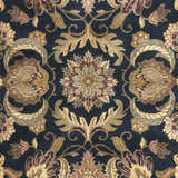 Close up of the Bays Area Carpet, a traditional rug with amber, brown, and blue floral patterns. Swatch